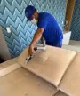 Técnico higienizando sofá na casa do cliente