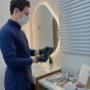 Biomédico Dr. Sidney Ruggero de máscara e luvas, organizando seringas e produtos para aplicação de Botox em clínica de estética.