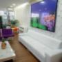 Sala de recepção da clínica Bonapele Estética, com sofás, poltronas, decoração moderna e TV, transmitindo acolhimento e conforto.